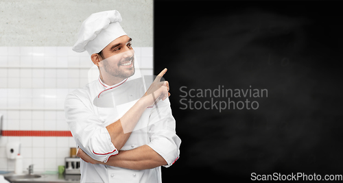 Image of happy smiling male chef with big black chalkboard