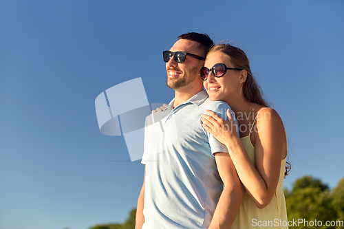 Image of happy couple hugging outdoors in summer