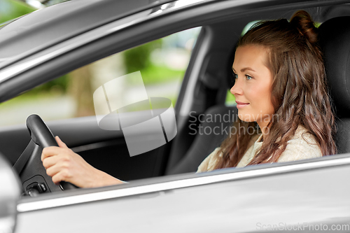 Image of woman or female driver driving car in city