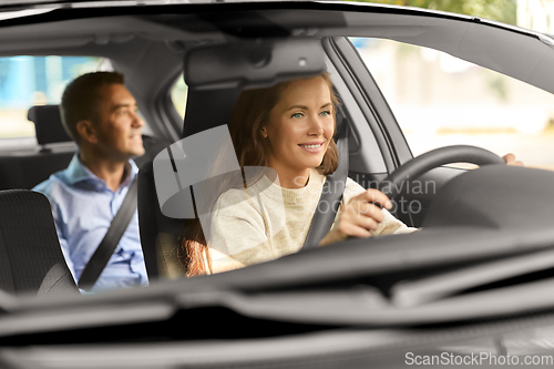 Image of female driver driving car with male passenger