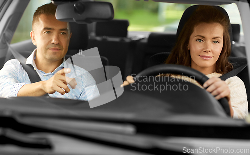 Image of car driving school instructor teaching woman