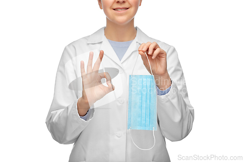 Image of smiling female doctor with mask showing ok sign