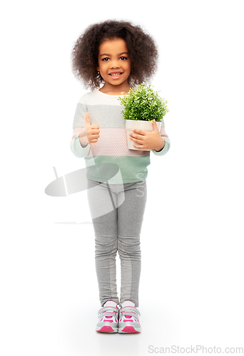 Image of smiling girl holding flower and showing thumbs up