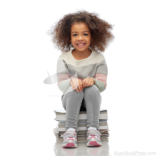 Image of smiling girl with magazines sorting paper waste