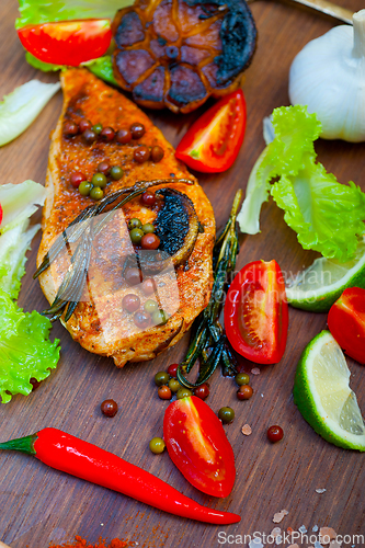 Image of wood fired hoven cooked chicken breast on wood board