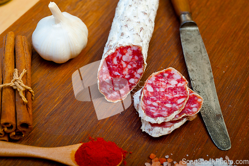 Image of traditional Italian salame cured sausage sliced on a wood board