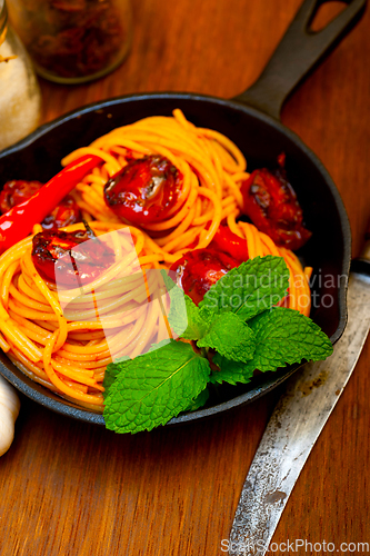 Image of italian spaghetti pasta and tomato with mint leaves
