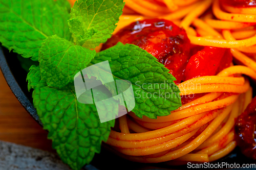 Image of italian spaghetti pasta and tomato with mint leaves