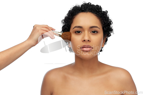 Image of woman and hand of make up artist with brush