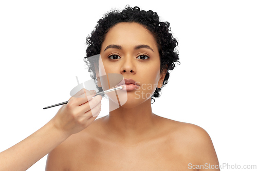 Image of woman and hand of make up artist with brush