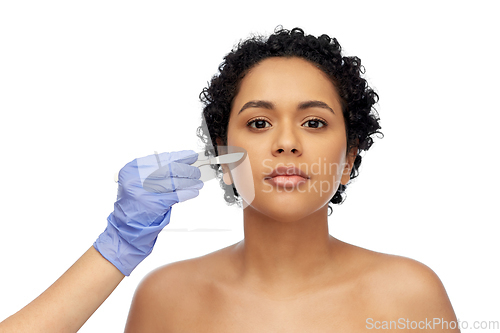 Image of african american woman and hand with scalpel knife