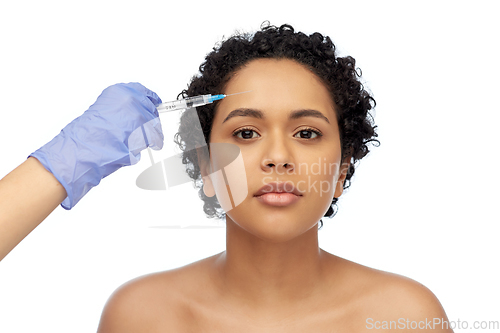 Image of face of african woman and hand with syringe