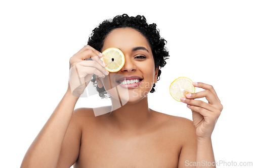 Image of african american woman making eye mask of lemons