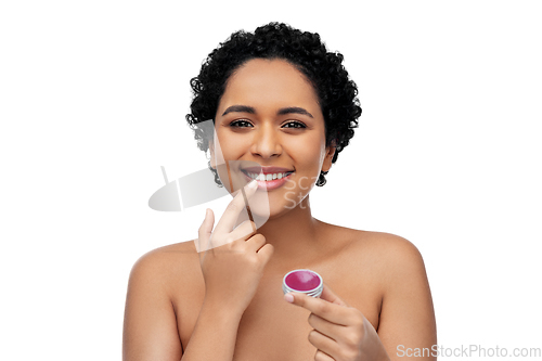 Image of african american woman applying lip gloss