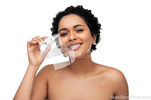 Image of happy young african american woman with eye drops