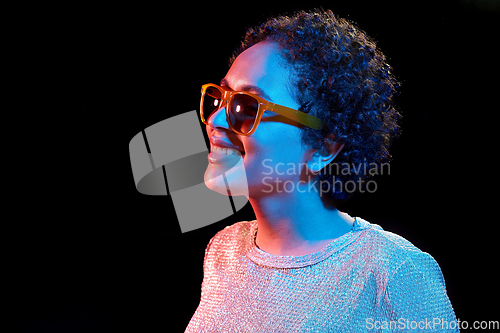 Image of african woman in sunglasses over neon lights