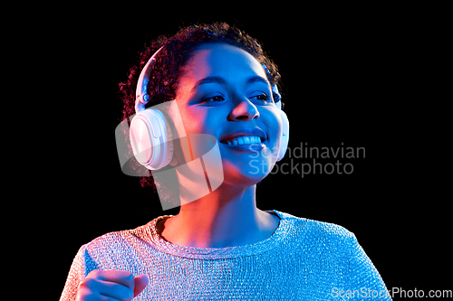 Image of woman in headphones listening to music and dancing