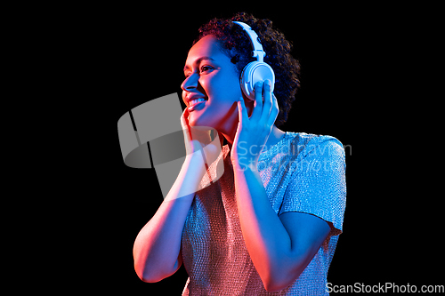 Image of woman in headphones listening to music and dancing