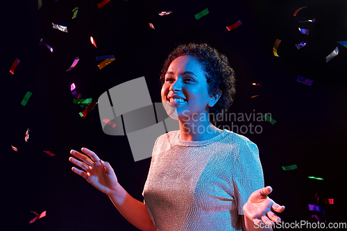 Image of african woman under confetti at nightclub party