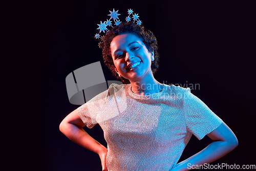 Image of african woman in party crown over black background
