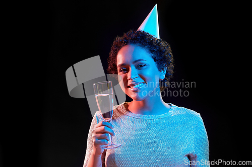 Image of african woman in party cap with glass of champagne