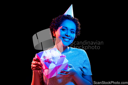 Image of african woman in party cap with gift box on black
