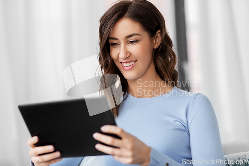Image of happy smiling young woman with tablet pc at home