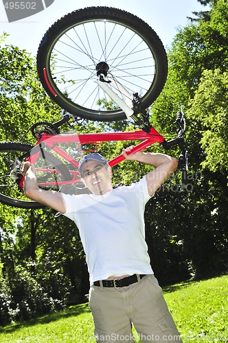 Image of Man carrying a bicycle