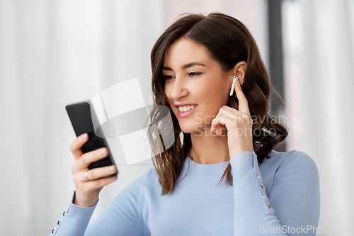 Image of woman with earphones and smartphone at home