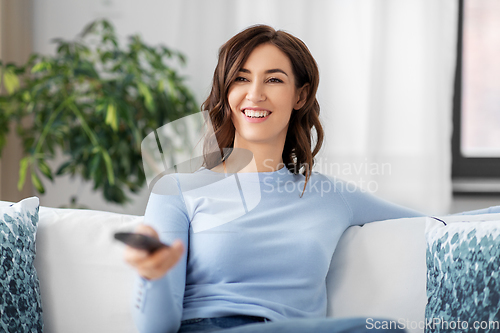 Image of happy woman watching tv at home