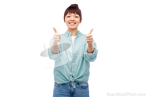 Image of happy asian woman showing thumbs up over white