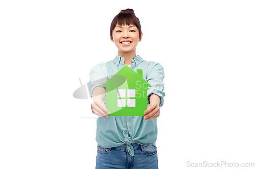 Image of smiling asian woman holding green house