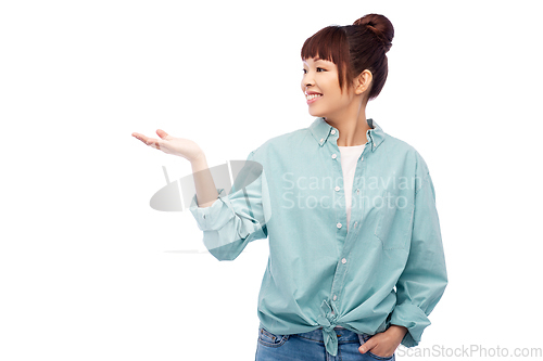 Image of happy asian woman holding something on hand