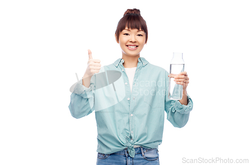 Image of happy asian woman holding glass bottle with water