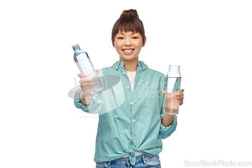 Image of asian woman with plastic and glass bottle of water