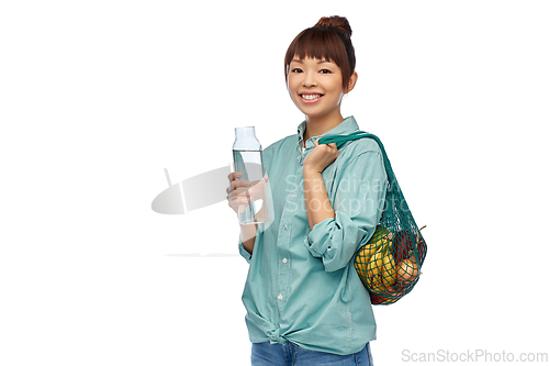 Image of woman with food in string bag and glass bottle