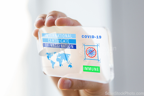 Image of hand holding phone with certificate of vaccination