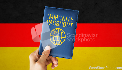 Image of hand holding immunity passport over german flag