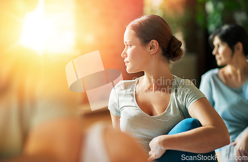 Image of woman with group of people doing yoga at studio