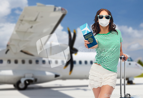 Image of woman in mask with ticket and immunity passport