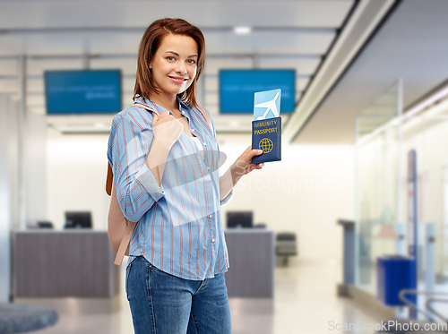 Image of happy woman with air ticket and immunity passport