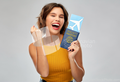 Image of happy woman with air ticket and immunity passport