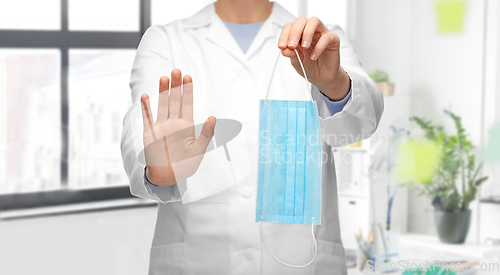 Image of female doctor with medical mask showing stop