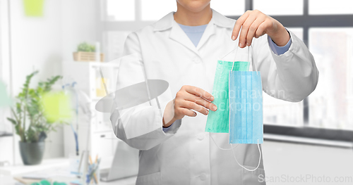 Image of female doctor showing two medical masks