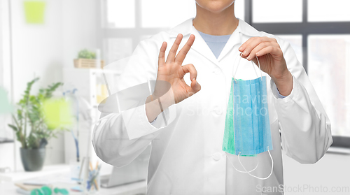 Image of female doctor with medical mask showing ok gesture