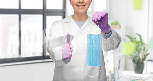 Image of female doctor with medical mask showing thumbs up