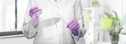 Image of female doctor with test tube and cotton swab