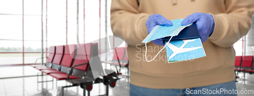 Image of woman with mask, passport and ticket at airport