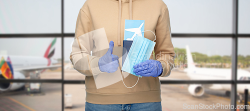 Image of woman with mask, passport and ticket at airport