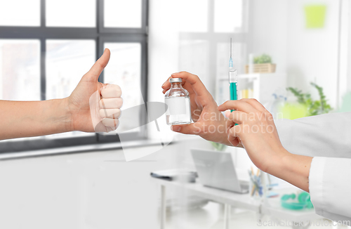 Image of hand with medicine and showing thumbs up